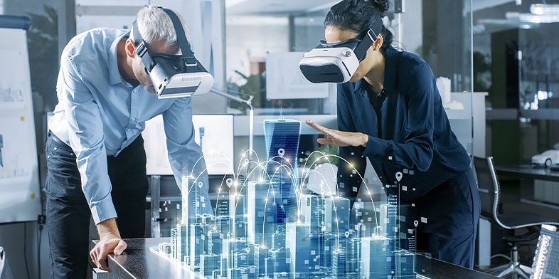 Male and female architects wearing AR headsets work with 3D city model projected on the table in front of them