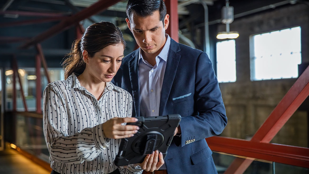 A woman shows man something on tablet