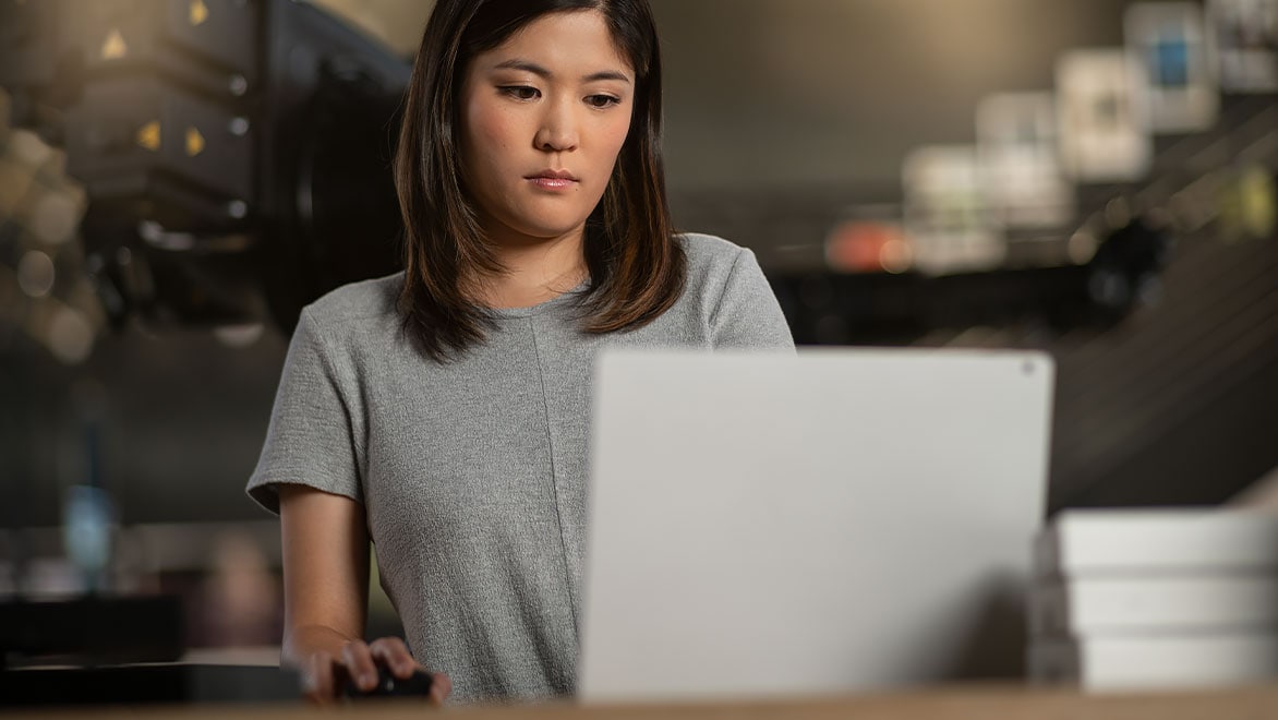 Woman using laptop with mouse