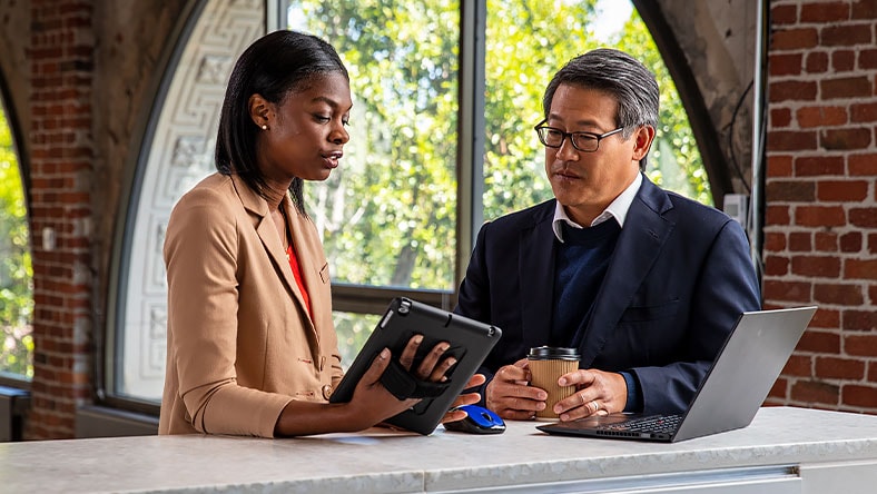 Woman shows tablet and explains to man