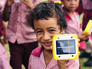 Student posing with a solar lamp