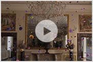 Video: flowers of different colors  swirling in the air inside an ornate Roman room 